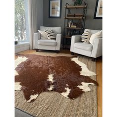 a living room with two chairs and a cowhide rug