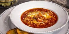 a white plate topped with a bowl of soup