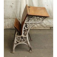 an old school desk and chair sitting on the floor