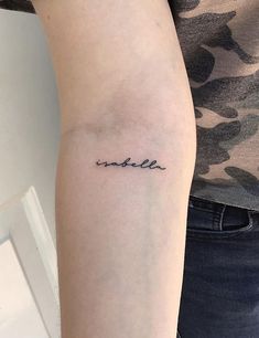 a woman with a small tattoo on her arm that says smile in cursive writing