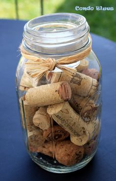 a jar filled with wine corks sitting on top of a blue tablecloth covered table