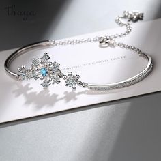 Crafted with delicate silver and shimmering crystals, our Fresh Snowflake Bracelet symbolizes purity and uniqueness. Each snowflake represents the beauty of individuality and the transformative power of winter. Embrace the enchanting story of snow as you wear this timeless piece, a reminder to cherish your own distinctive journey.   - Brand: Thaya  - Material: Environmentally friendly copper plated real gold  - Size: Bracelet length 16cm+5cm extension chain  - Shape: Snowflake  - Gender: Women's Snowflake Bracelet, Wedding Bride Jewelry, Wholesale Gifts, Jewelry Blue, Friends Mom, Copper Bracelet, Crystal Wedding, Bride Jewellery, Copper Plated