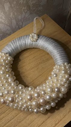 a wreath made out of pearls on top of a wooden table