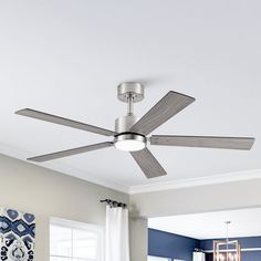 a ceiling fan in a living room with blue walls