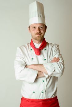 a man in a chef's uniform with his arms crossed