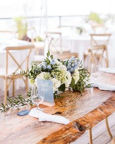 a wooden table topped with white and blue flowers