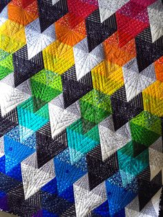 a multicolored quilt is hanging on the wall