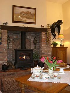 a living room filled with furniture and a fire place in front of a brick fireplace