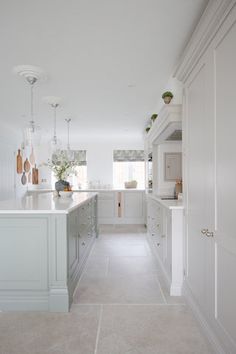 a large kitchen with white cabinets and counter tops