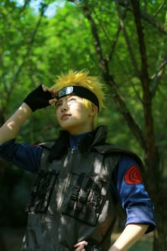 a young man with yellow hair wearing a black vest and blindfold