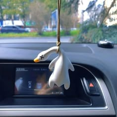 a car dashboard with a fake ghost hanging from it's dash board in front of the steering wheel