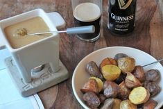 a bowl full of potatoes next to a bottle of guinness beer and a toaster