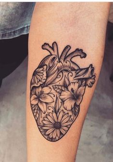 a black and white heart tattoo with flowers on the side of the calf's leg