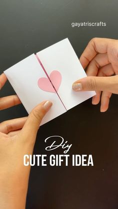 two hands holding up a card that says diy cute gift idea with hearts on it