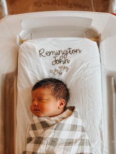 a baby sleeping in a white crib with the name reunion john on it's back