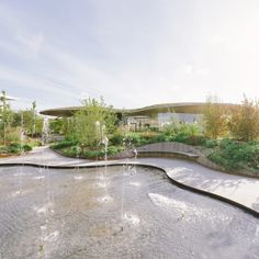 a large pond with water spouting from it's sides in front of a building