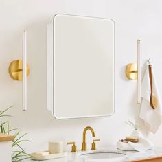 a bathroom sink with a mirror and gold faucets on the wall next to it