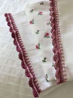 three pieces of white and pink crocheted fabric