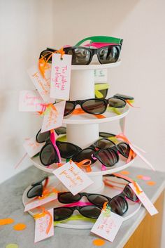 a stack of sunglasses on top of a counter next to confetti streamers