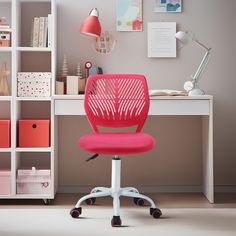 a pink office chair sits in front of a desk with bookshelves and shelves