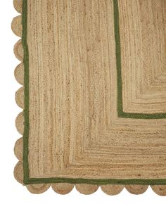 an area rug with scalloped edges and green trim