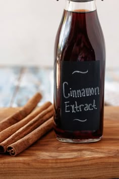 cinnamon extract in a glass bottle next to cinnamon sticks on a cutting board with a chalkboard label