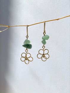 two pairs of earrings hanging from a clothes line with green glass beads and gold plated hooks