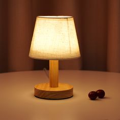 a table with a lamp and two cherries on it