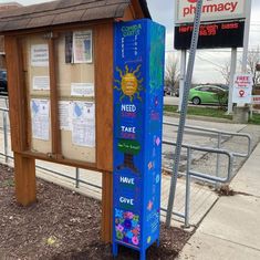 a blue phone booth sitting on the side of a road