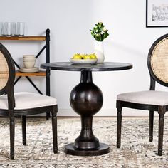 a table with two chairs and a bowl of fruit on the table in front of it