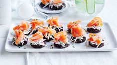 small appetizers are arranged on a white platter