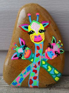 a painted rock with a giraffe on it