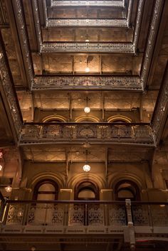 the inside of an old building with several balconies and lights hanging from the ceiling