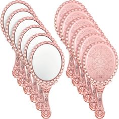 a set of six pink mirrors with tassels on each one and an oval mirror in the middle