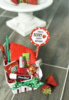 a basket filled with candy and strawberries on top of a table