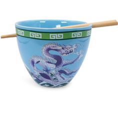 a blue bowl with a dragon painted on it and two chopsticks sticking out