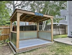 a wooden gazebo sitting in the middle of a yard