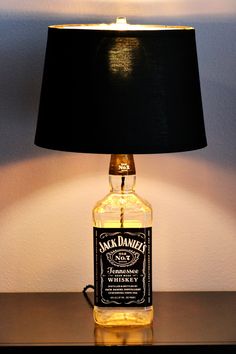 a lamp that is on top of a table with a bottle in front of it