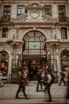 many people are walking in front of a building