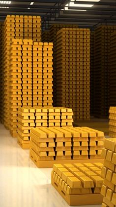 stacks of gold bars in a warehouse with white flooring and yellow lighting on the ceiling