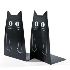 two black cat shaped bookends with eyes and legs on each one's sides