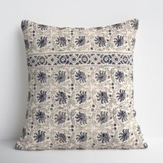 a white and blue pillow sitting on top of a table