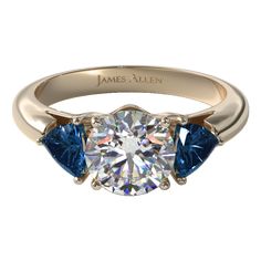 a diamond and blue sapphire engagement ring with the name james allen in gold on it