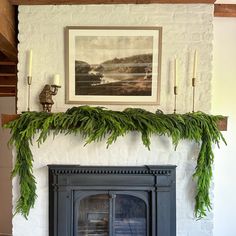 the fireplace is decorated with greenery and candles