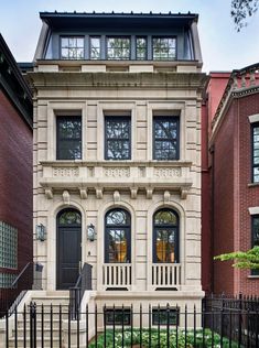 an old building with many windows and wrought iron fence around the front door is shown