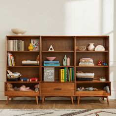 a bookshelf filled with lots of books on top of a hard wood floor