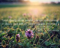 a purple flower in the grass with a quote from alice walker about looking closely at the present you are constructing