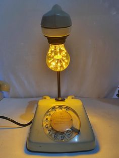 an old fashioned phone with a light bulb on top