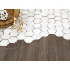 a white and brown bathroom with hexagonal tiles on the floor, wooden table