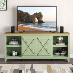 a flat screen tv sitting on top of a green cabinet